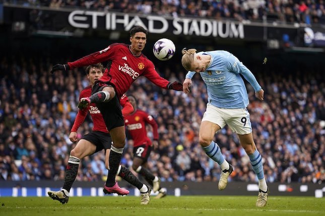 Duel Raphael Varane vs Erling Halaand di laga Manchester City vs Manchester United di pekan 27 Liga Inggris 2023/24 di Etihad, Minggu (03/03/2024). (c) AP Photo/Dave Thompson