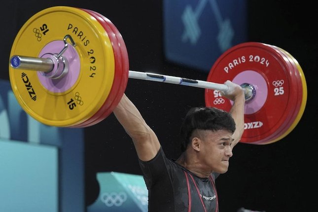 Atlet angkat besi putra Indonesia, Rizki Juniansyah, meraih medali emas kelas 73 kg Olimpiade Paris 2024. (c) AP Photo/Kin Cheung