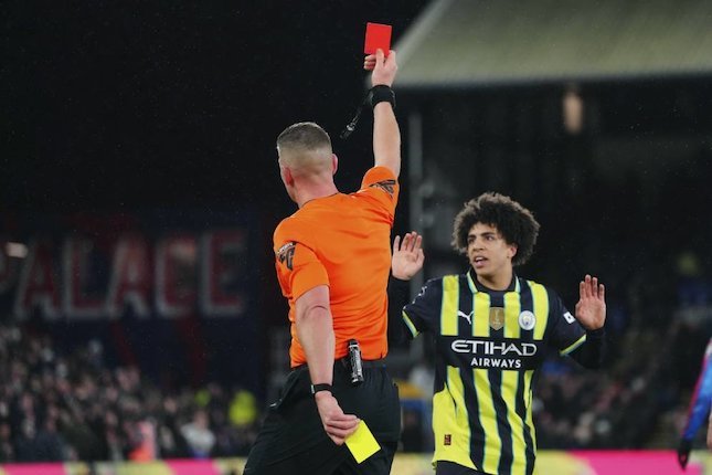 Rico Lewis dari Manchester City menerima kartu merah dari wasit Rob Jones dalam pertandingan Premier League melawan Crystal Palace di Selhurst Park, Sabtu, (7/12/2024). (c) AP Photo/Dave Shopland