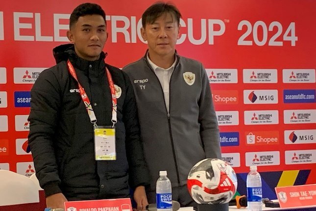 Rivaldo Pakpahan (kiri) dan Shin Tae-yong dalam konferensi pers pralaga Vietnam vs Indonesia di Piala AFF 2024 (c) Bola.net/Asad Arifin