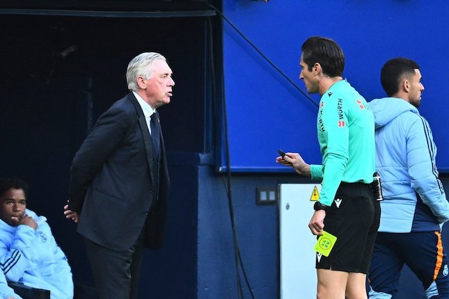 Carlo Ancelotti menerima kartu kuning dari wasit Munuera Montero dalam laga La Liga antara Osasuna vs Real Madrid, Sabtu (15/2/2025). (c) AP Photo/Miguel Oses
