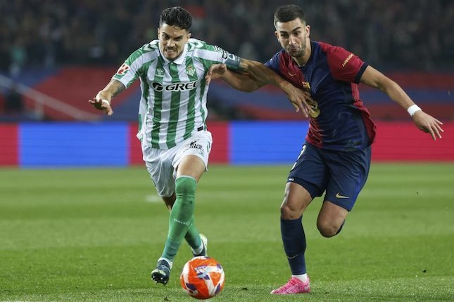 Puji Torres Marc Bartra (kiri) dan Ferran Torres berebut bola dalam laga Barcelona vs Real Betis di La Liga, Minggu (6/4/2025) dini hari WIB. (c) AP Photo/Joan Monfort