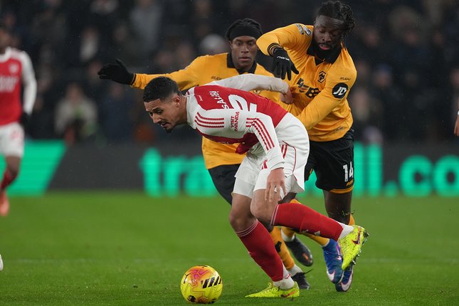 William Saliba berebut bola dengan Tolu Arokodare dalam laga Premier League antara Wolverhampton vs Arsenal di Molineux Stadium, 19 Februari 2026 (c) AP Photo/Dave Shopland
