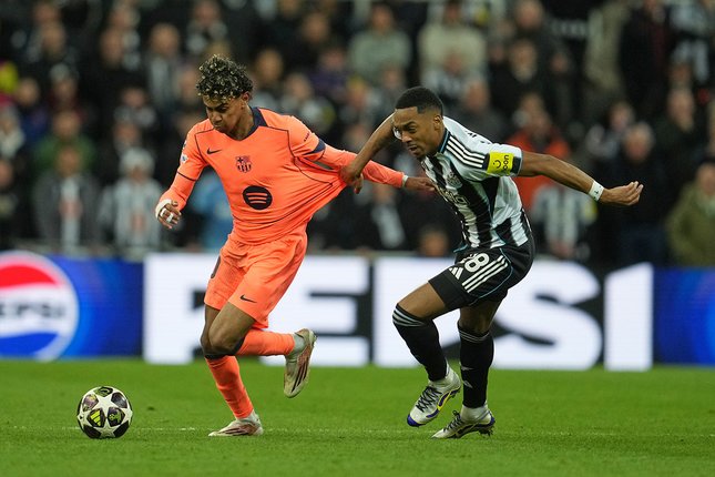 Pemain Newcastle, Joe Willock mencoba menghentikan pergerakan winger Barcelona, Lamine Yamal di duel Liga Champions, 11 Maret 2026. (c) AP Photo/Jon Super