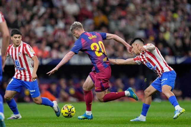 Pemain Barcelona, Dani Olmo (tengah), melindungi bola dari pemain Atletico Madrid, Thiago Almada dalam pertandingan La Liga, Minggu (5/4/2026) dini hari WIB. (c) AP Photo/Bernat Armangue