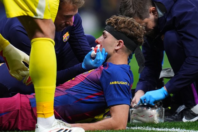 Alami Cedera Kaki Fermin Lopez mendapat perawatan dari tim medis usai mengalami cedera dalam laga Atletico Madrid vs Barcelona di perempat final Liga Champions, Rabu (15/4/2026). (c) AP Photo/Manu Fernandez