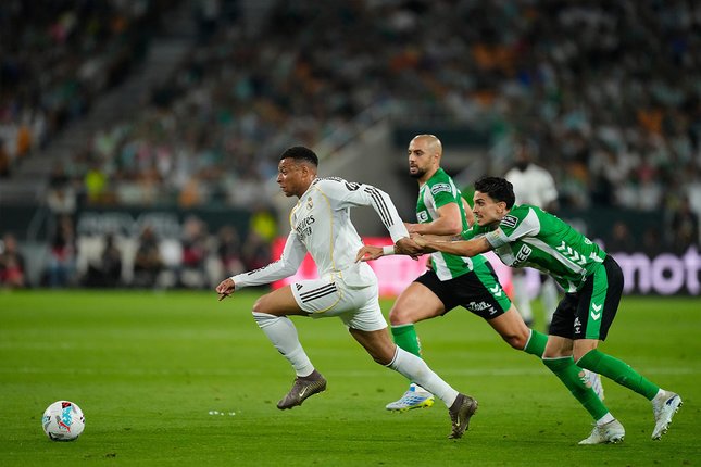 Pergerakan penyerang Real Madrid, Kylian Mbappe coba dihentikan bek Real Betis, Marc Bartra, 25 April 2026 di lanjutan La Liga. (c) AP Photo