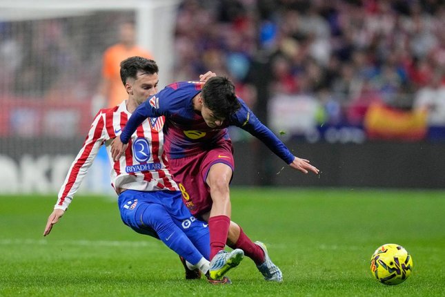 Pemain Barcelona, Pedri (kanan), berebut bola dengan pemain Atletico Madrid, Alex Baena dalam pertandingan La Liga, Minggu (5/4/2026) dini hari WIB. (c) AP Photo/Bernat Armangue