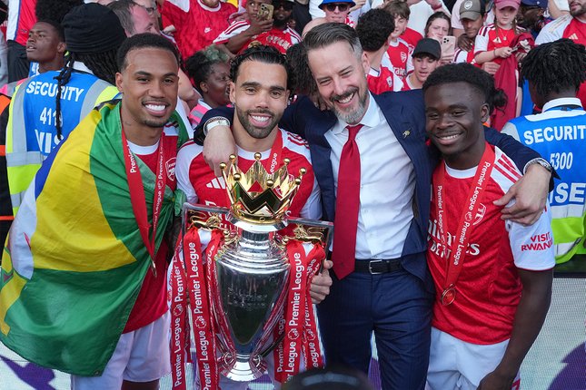 Raya Naik, Ramsdale Tenggelam Dari kiri-kanan: Bek Arsenal Gabriel, David Raya, Co-Chairman Josh Kroenke, dan Bukayo Saka berpose dengan trofi Liga Inggris, 25 Mei 2026. (c) AP Photo/Kin Cheung
