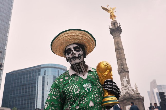 Antusiasme menyambut Piala Dunia FIFA 2026 terlihat di Mexico City. Seorang penari membawa replika trofi Piala Dunia di jalanan Meksiko. (c) AP Photo/Moises Castillo
