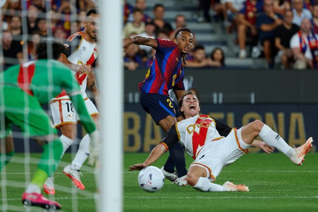 Kiper dan Bek Pemain Barcelona, Jules Kounde (tengah), berebut bola dengan pemain Rayo Vallecano, Oscar Valentin, dalam pertandingan La Liga, Selasa (1/9/2026). (c) AP Photo/Joan Monfort