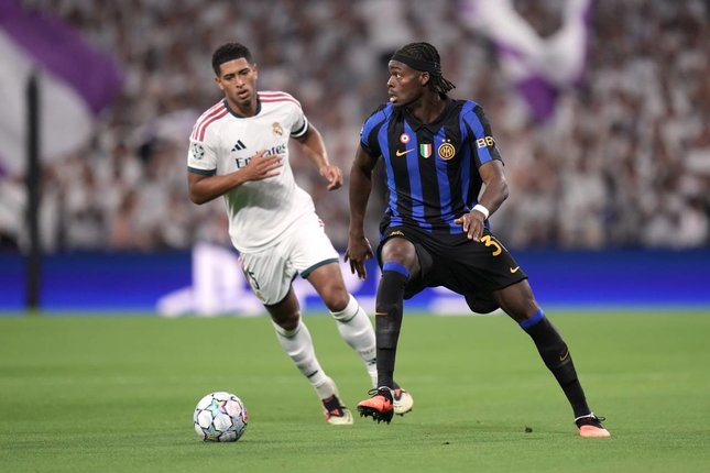 Sepakati Kontrak Jangka Panjang Pemain Inter Milan, Yann Bisseck, berduel memperebutkan bola dengan pemain Real Madrid, Jude Bellingham, dalam pertandingan Liga Champions, Rabu (9/9/2026). (c) AP Photo/Bernat Armangue
