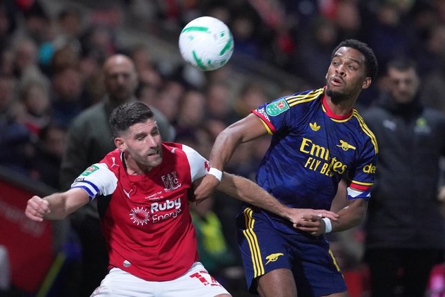 Pemain Fleetwood Town, Ched Evans berebut bola dengan pemain Arsenal Jurrien Timber, dalam pertandingan Carabao Cup, Rabu (28/10/2026). (c) AP Photo/Ian Hodgson
