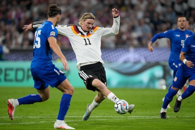 Jurgen Klopp Waspadai Laga di Yunani Pemain Jerman Nick Woltemade (tengah) dan pemain Serbia Srdjan Babic berebut bola dalam pertandingan UEFA Nations League, Jumat (2/10/2026). (c) AP Photo/Matthias Schrader