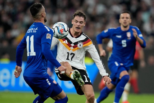 Klopp Soroti Intensitas Jerman Pemain Jerman Florian Wirtz (tengah) dan pemain Serbia Filip Kostic (kiri) berebut bola dalam pertandingan UEFA Nations League, Jumat (2/10/2026). (c) AP Photo/Matthias Schrader