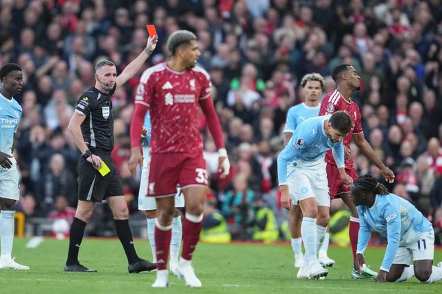 Bisa Sapu Bersih Wasit Chris Kavanagh menunjukkan kartu merah kepada pemain Liverpool Ryan Gravenberch dalam pertandingan Premier League kontra Manchester City, Minggu (11/10/2026). (c) AP Photo/Jon Super