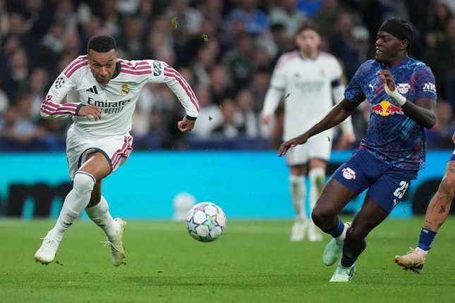Pemain Real Madrid, Kylian Mbappe berebut bola dengan pemain RB Leipzig Castello Lukeba dalam pertandingan Liga Champions, Kamis (22/10/2026). (c) AP Photo/Bernat Armangue