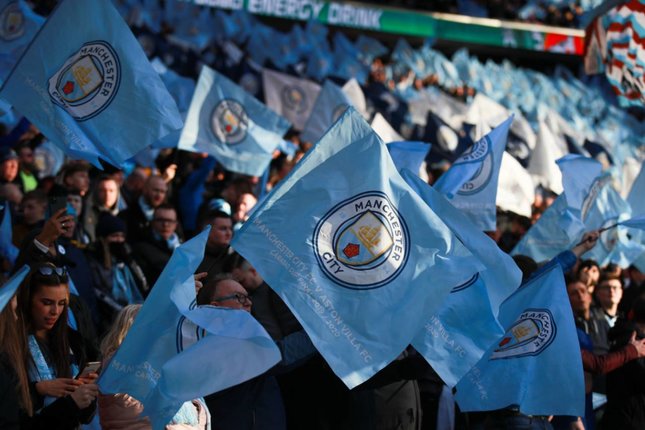 Premier League Didesak Menentukan Sanksi Suporter Manchester City mengibarkan bendera tim sebelum pertandingan final Piala Liga Inggris melawan Aston Villa, Minggu (1/3/2020). (c) AP Photo/Ian Walton