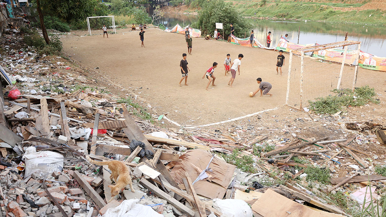 Potret Anak-anak Ibu Kota Bermain Sepak Bola di Pinggir Kali