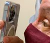 Dokter menggunakan iPhone 13 Pro Max untuk memeriksa mata pasien.