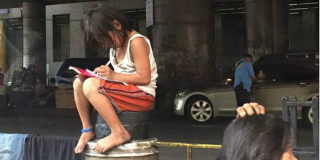 Foto Menyedihkan Gadis Kecil Kerjakan PR di Pinggir Jalan