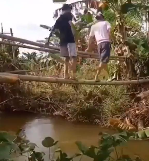 Berjalan meniti jembatan bambu bersama teman.