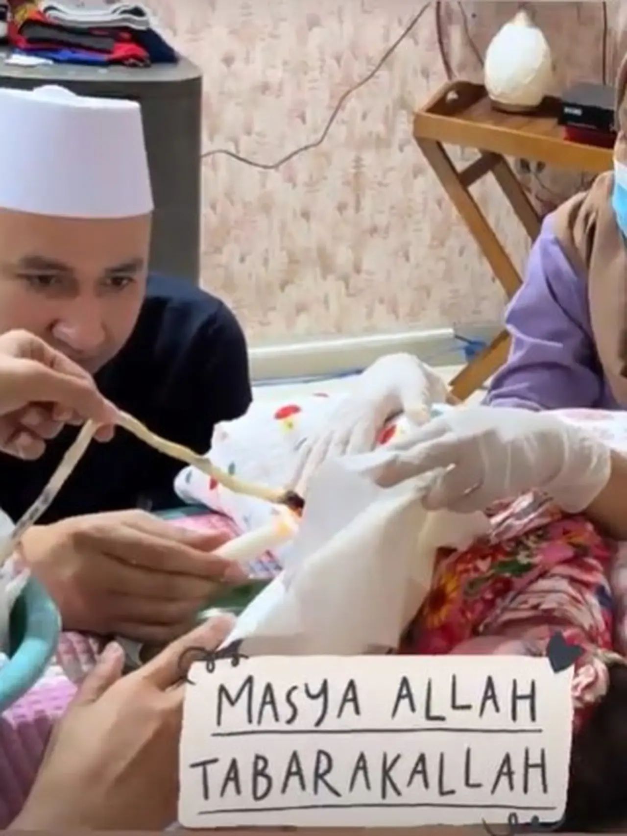 Kartika Putri's husband cutting the umbilical cord of their second child