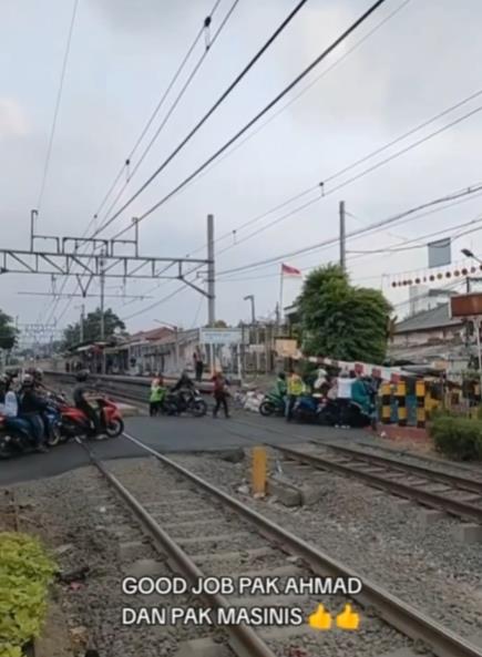 Viral dozens of motorcyclists causing traffic jams at the railway crossing gate.