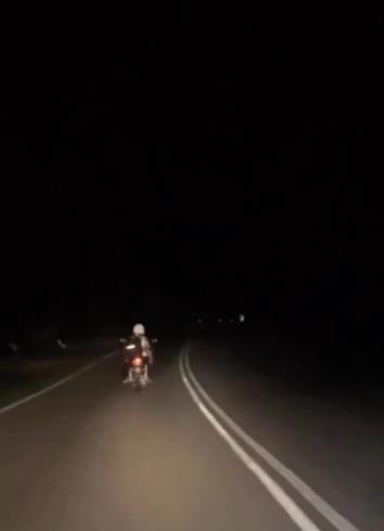 Girl's action of providing lighting for a grandfather's motorcycle without a front light.