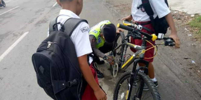 Bantu Anak  SD  Perbaiki Sepeda  Polisi Ini Panen Pujian 