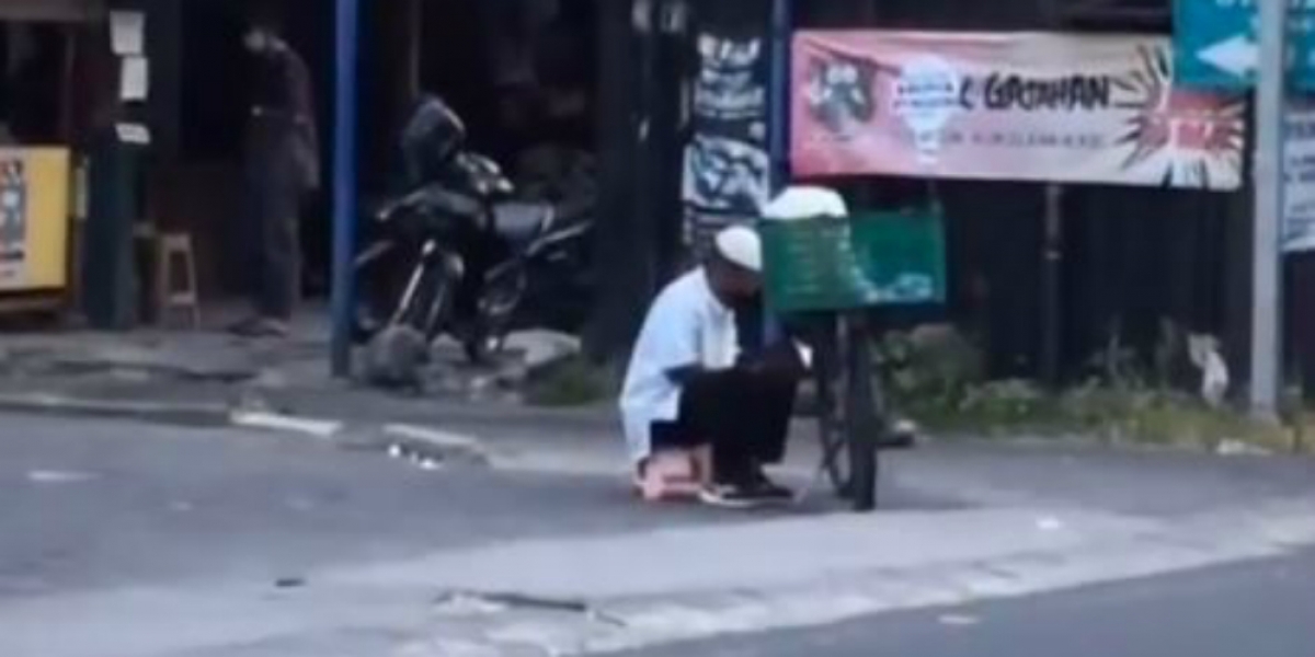 Sembari Tunggu Pembeli Penjual Kerupuk Pinggir Jalan Ini Mengaji Alquran