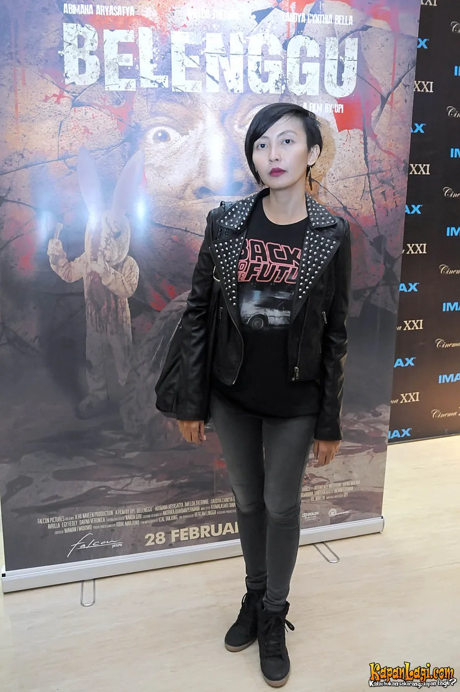 Upi membawa tas hitam, dan hanya memakai aksesori berupa anting bulu berwarna hitam