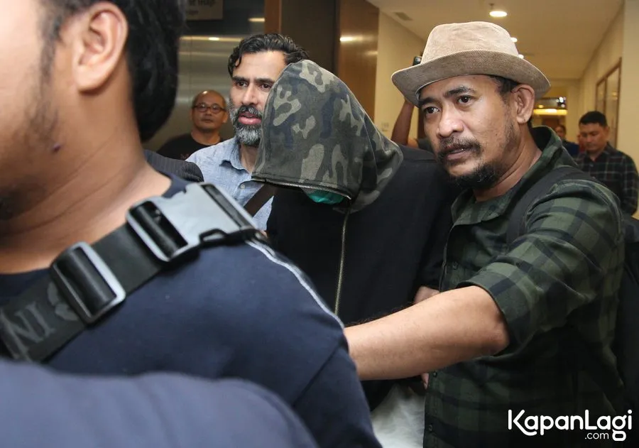 Axel tutupi wajahnya saat digiring pihak keamanan © KapanLagi.com®