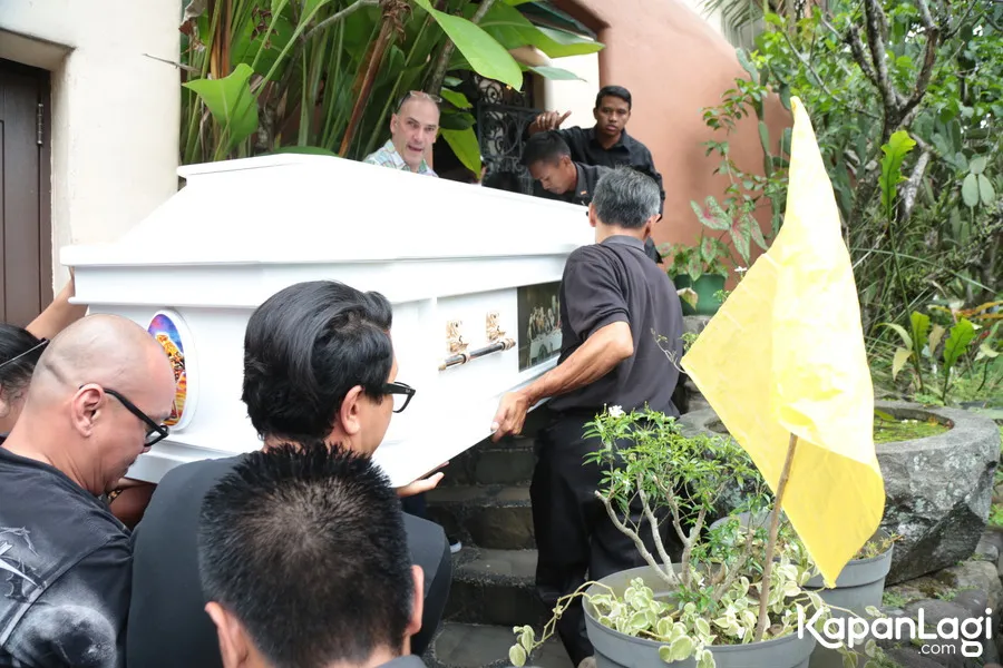 Terlihat Eliseo, anak kedua dari Pak Bondan, membantu mengangkat peti mati jenazah sang ayah. /© KapanLagi.com/Muhammad Akrom Sukarya