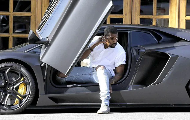 Kanye West saat turun dari Lamborghini miliknya saat akan menghadiri sebuah rapat @dailymail.co.uk