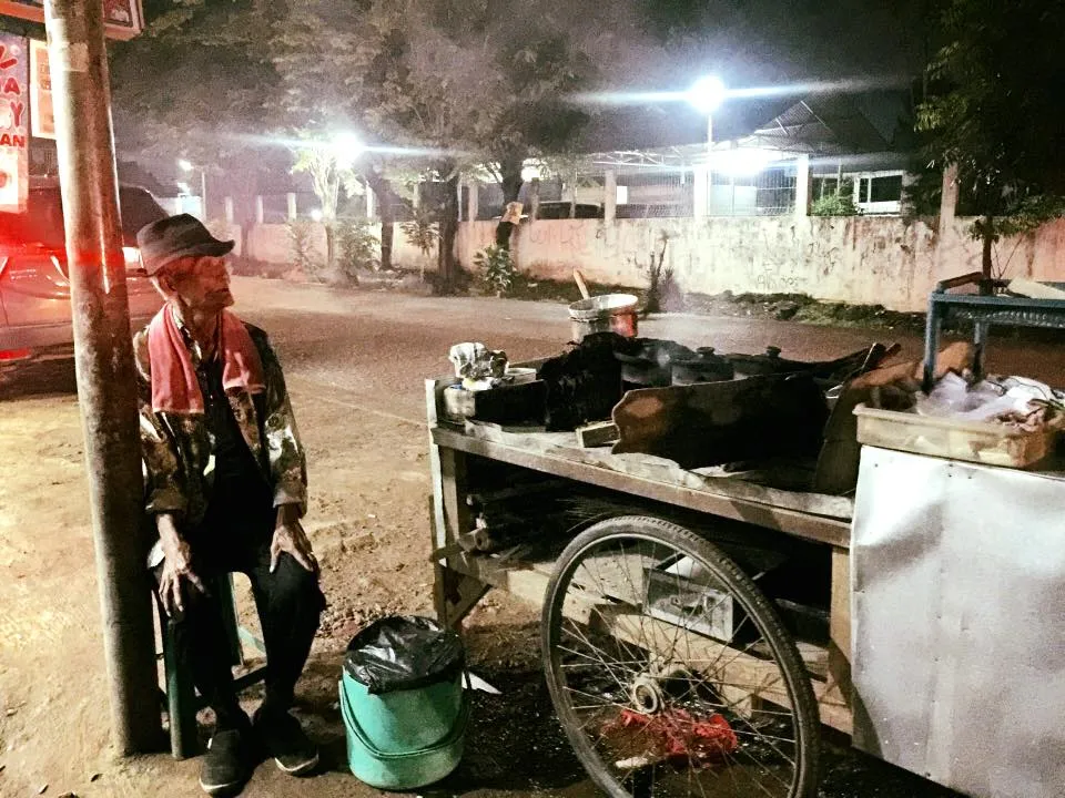 Kakek Penjual Serabi ini berusia 80 tahun namun masih semangat berjualan meski hari hujan dan pembeli tak kunjung datang © Facebook.com/Vicky Virgianti