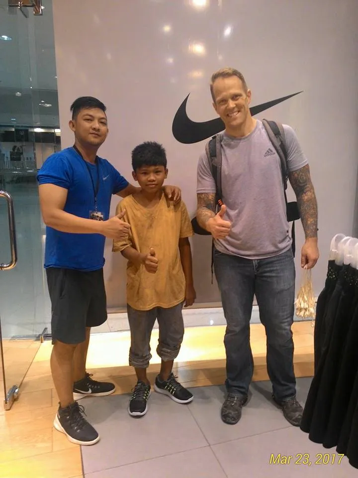 Kris Carroll bersama seorang bocah yang dibelikannya sepatu © Facebook.com/Ahyan Yerro