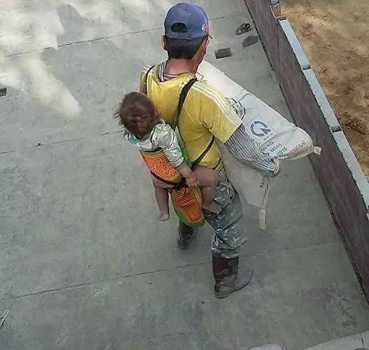 Pria asal Vietnam ini menjadi viral setelah fotonya saat bekerja sambil menggendong anak diunggah ke internet © viral4real.com