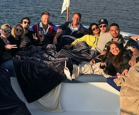Priyanka dan Nick (kanan, berbaju kuning) bermesraan di atas yatch. (Cr: instagram.com/glenpowell_)