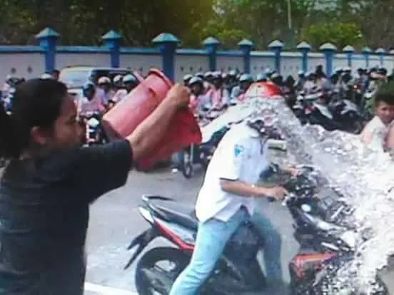 Ibu-Ibu di Madiun menyiram air bekas cucian piring pada pelajar peserta konvoi kelulusan © Facebook.com/Komunitas Paguyuban Madiun