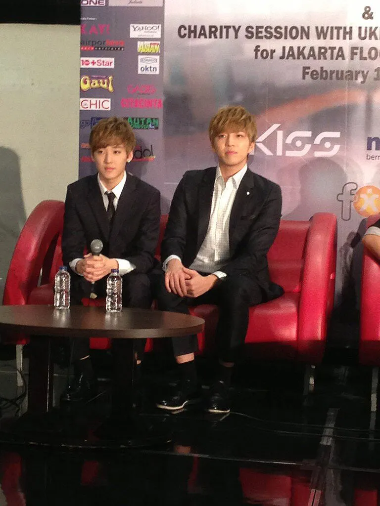 Member Kevin dan Soohyun saat melakukan lelang untuk disumbangkan pada korban banjir © @kpopzoneID | KMI + Ve