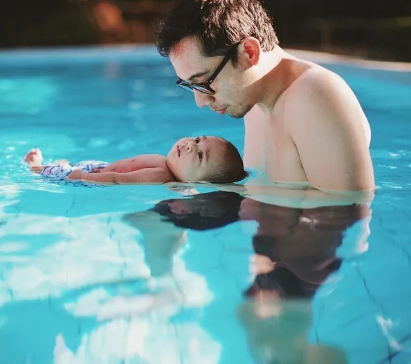 Baby Kawa menatap sang ayah saat berada di permukaan air kolam renang. /©instagram.com/andienaisyah