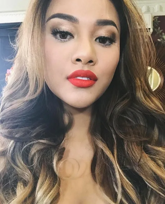 Kali ini Aurel tunjukkan warna lipcream merah dengan rambut panjang bergelombang. /©instagram.com/aurelie.hermansyah