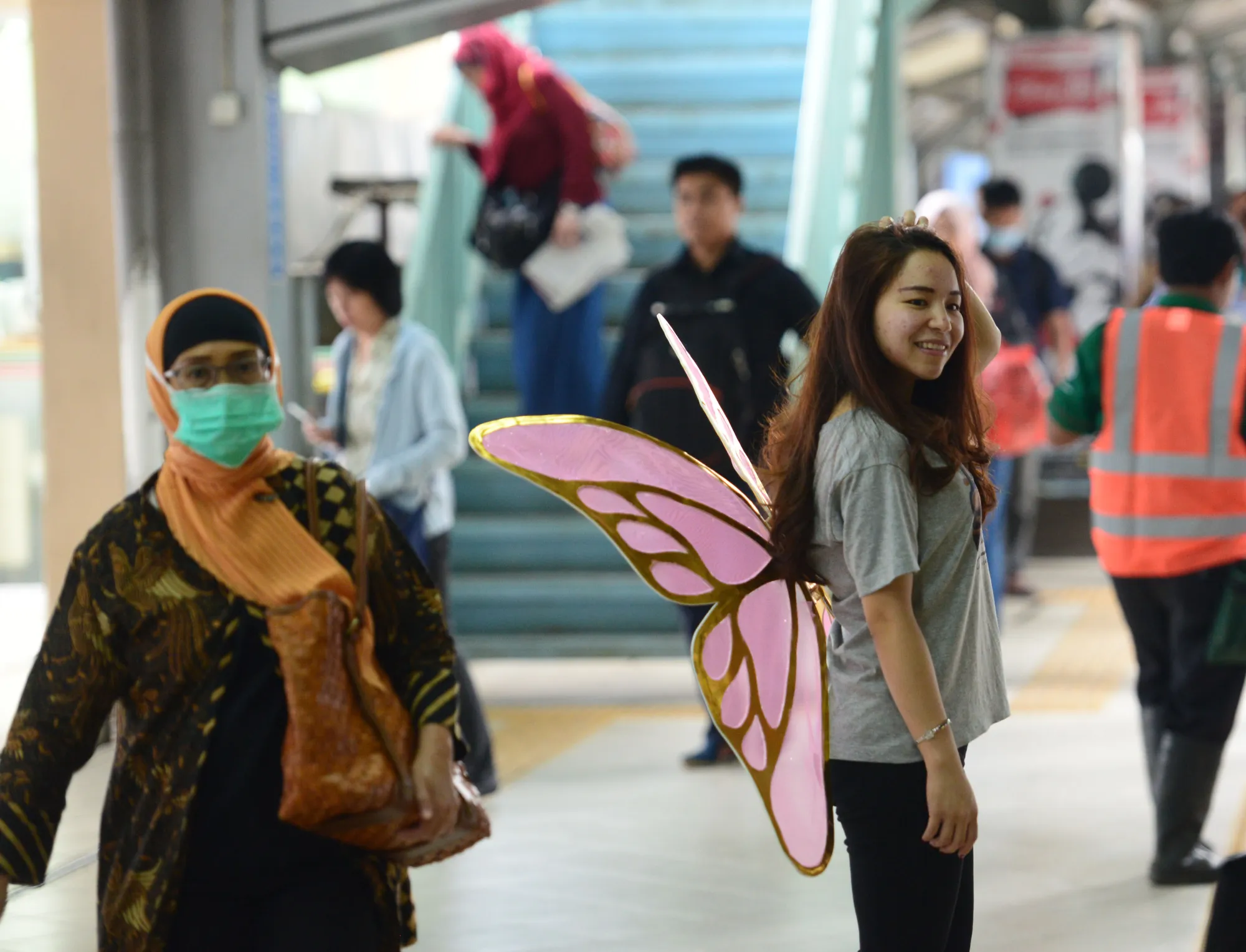 Meski pusat perhatian karena sayap pink yang nempel di punggungnya, tapi cewek ini kelihatan cuek