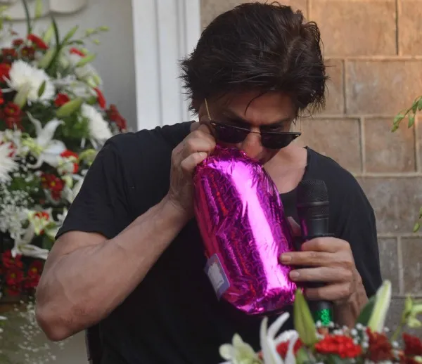 Shahrukh membuka kado yang ia terima dari para fansnya. @bollywoodlife