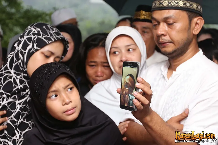 Edwin Manangsang mengikuti prosesi pemakaman Yanni Libels dengan video call. ©KapanLagi.com®/Busan