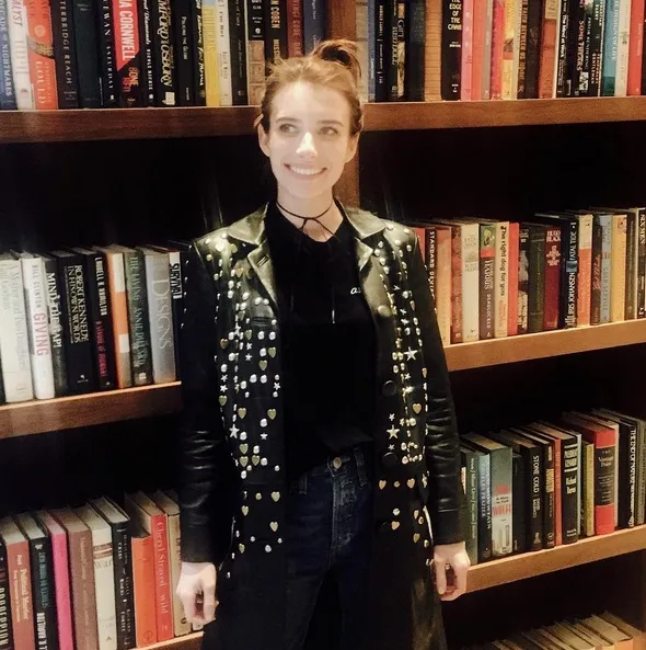 Senyum ceria Emma Roberts berpose di hadapan sebuah rak penuh dengan buku. /©instagram.com/emmaroberts