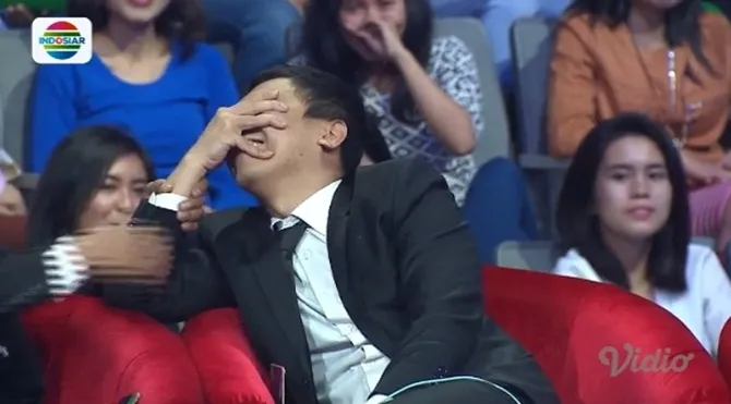 Mendengar sindiran Davis, Raditya Dika menahan tawa sambil menutup wajahnya.