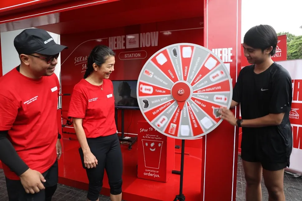 Rebecca Tan, President Director & CEO of Generali Indonesia (center) with Windra Krismansyah, Head of Corporate Communication (left), while assisting visitors trying spin to win