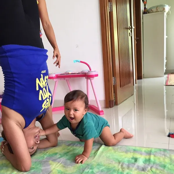 Indah Kalalo digangguin putranya ketika sedang headstand/©instagram.com/indahkalalo